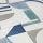 Roman blind with white background and blue, teal, and gray geometric shapes, folded in horizontal pleats; fabric lies flat, showing printed semicircles, rectangles and triangles in soft indoor lighting.
