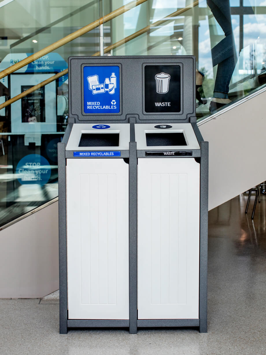 grey and white recycled plastic lumber mixed recyclables and waste container with sign frame and signs in a medical center