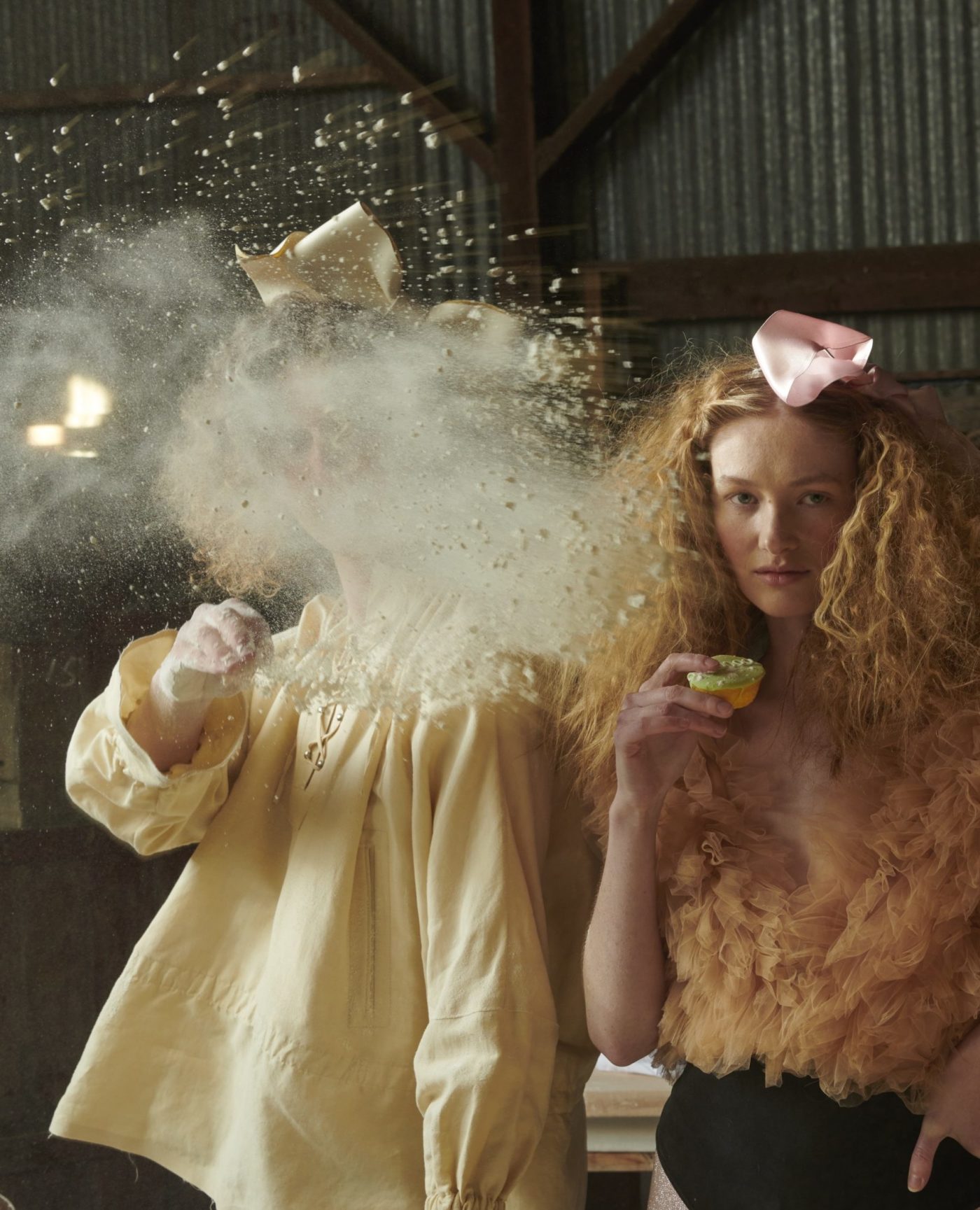 two women standing next to each other with powder in the air.