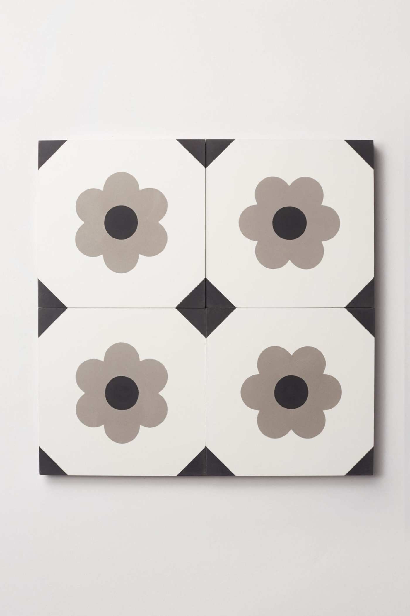 four tiles with black and white flowers on them.