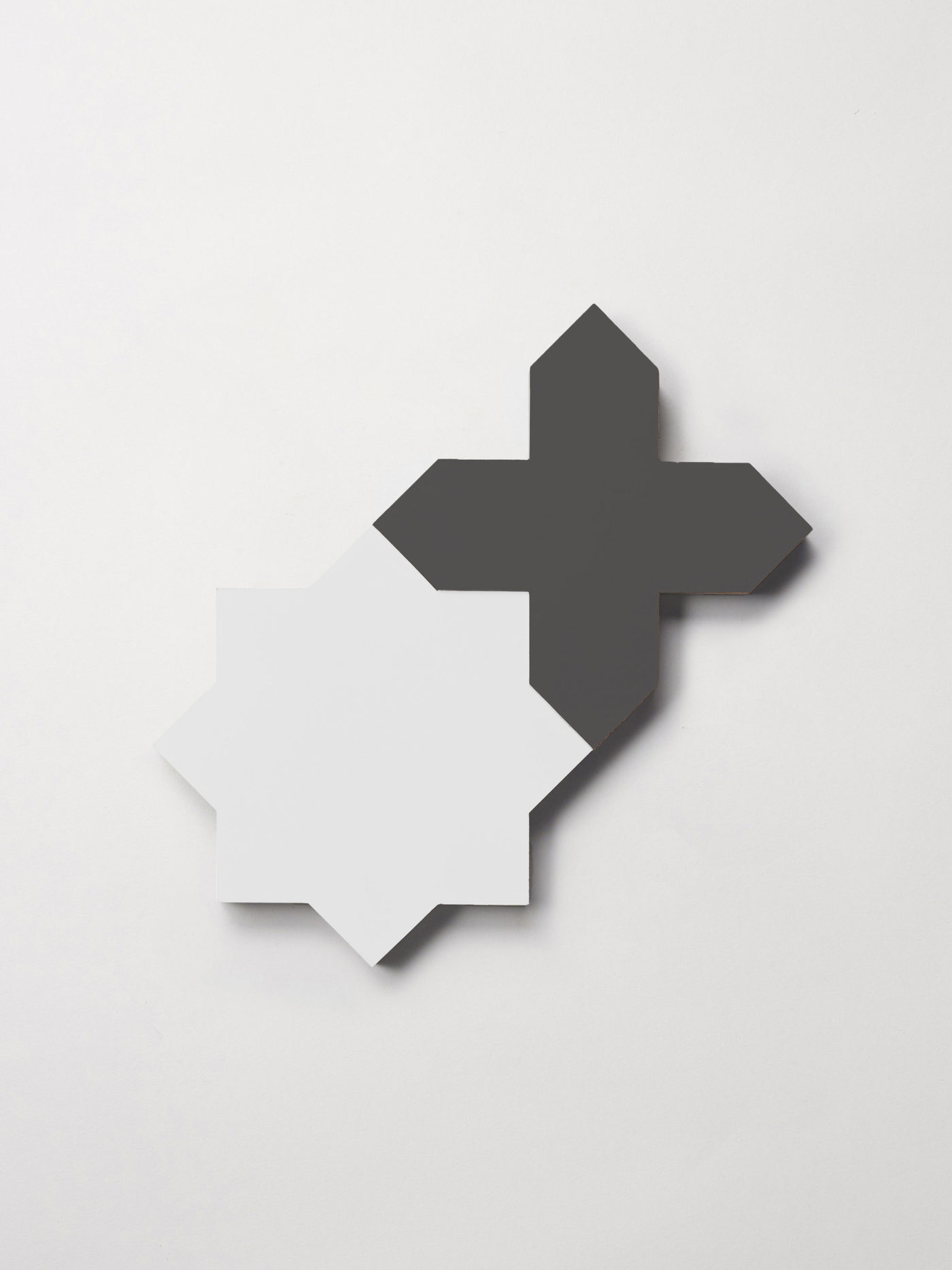 a white star and black cross tile on a white surface.