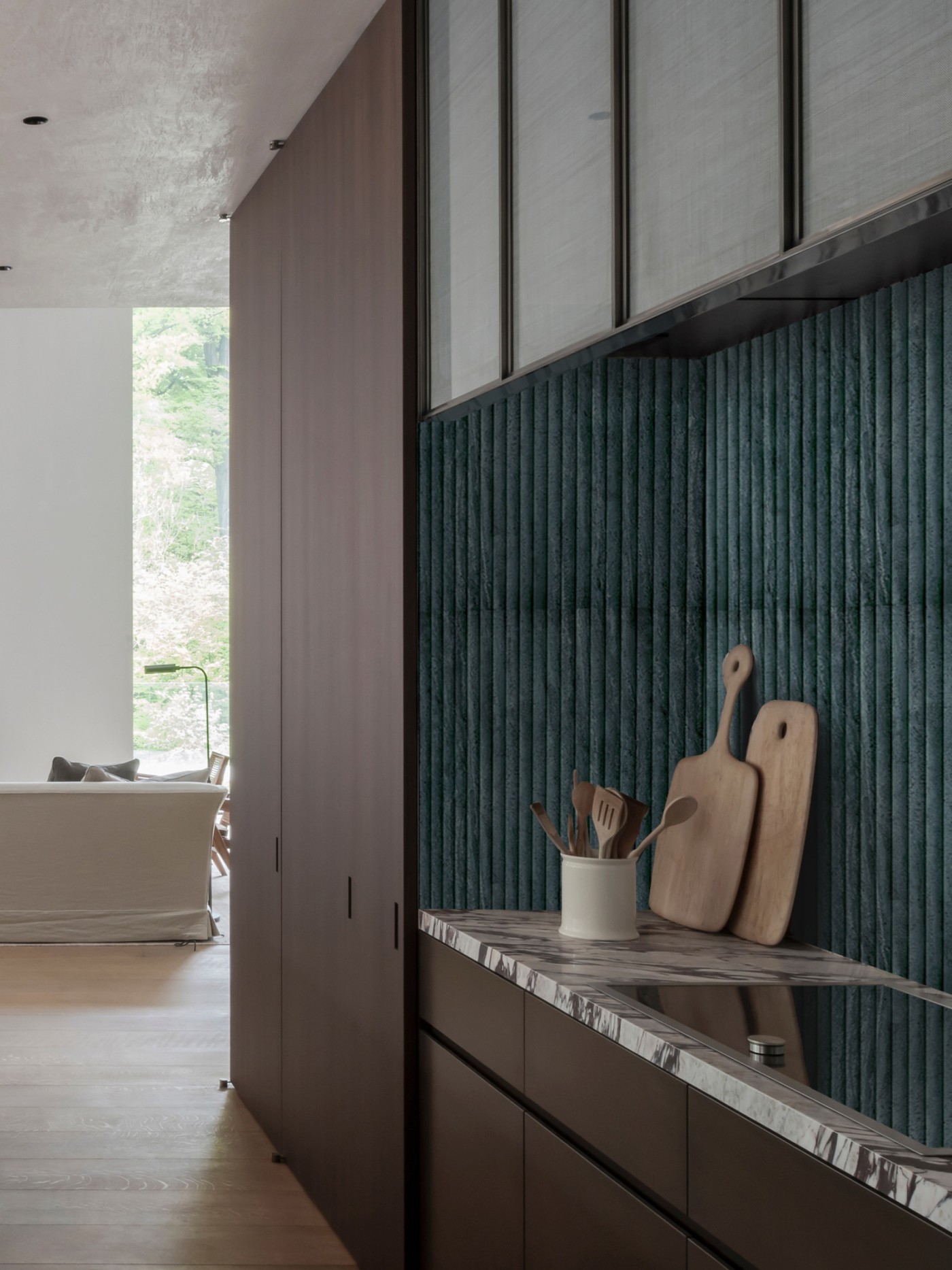 a kitchen with a wooden floor and a green tiled wall.