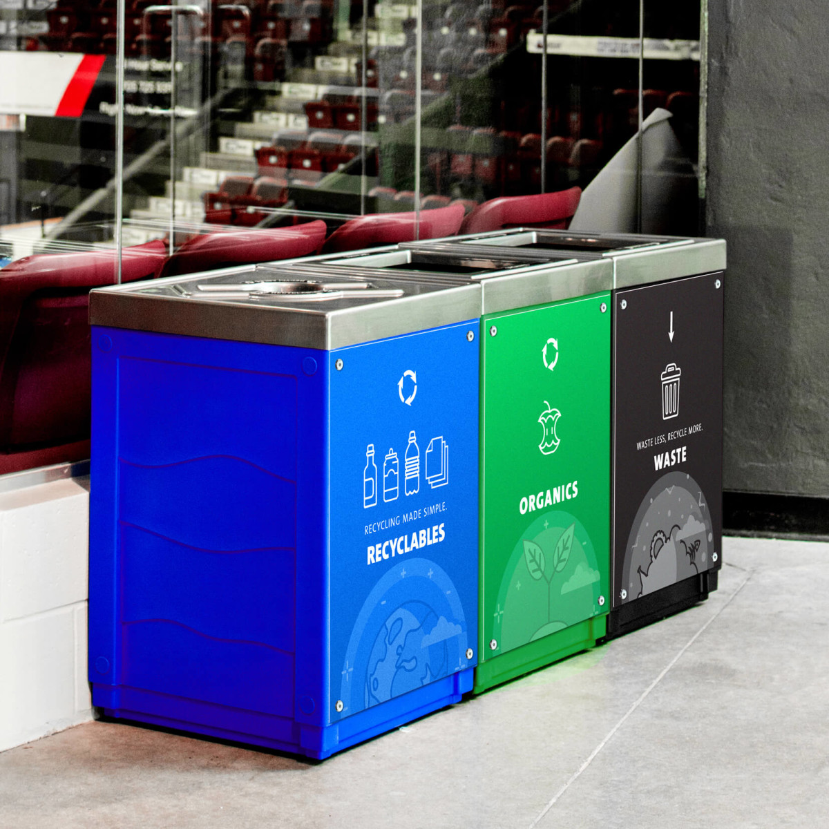 triple recycling organics and waste station with color-coded bodies and body signs in the main concourse of a hockey arena