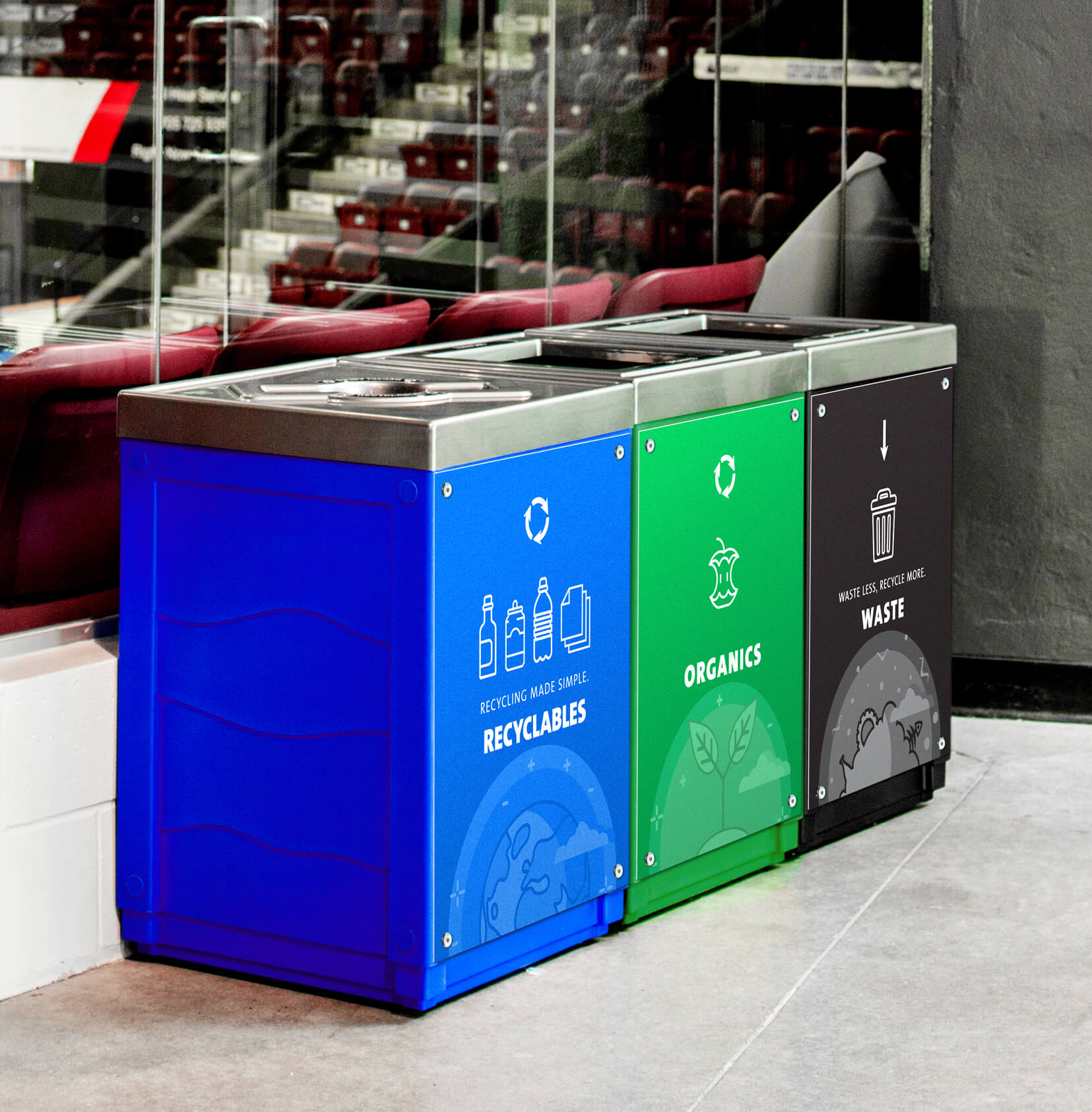 triple recycling organics and waste station with color-coded bodies and body signs in the main concourse of a hockey arena