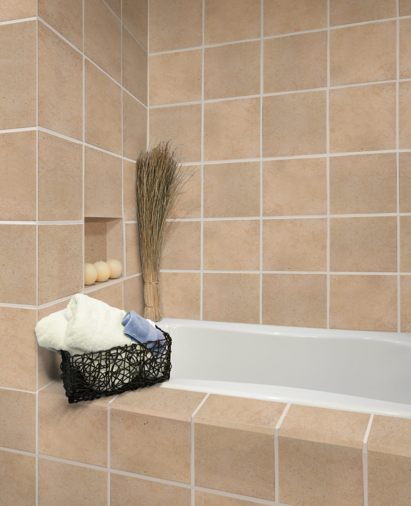 Tan limestone square tiles surrounding a bathtub.