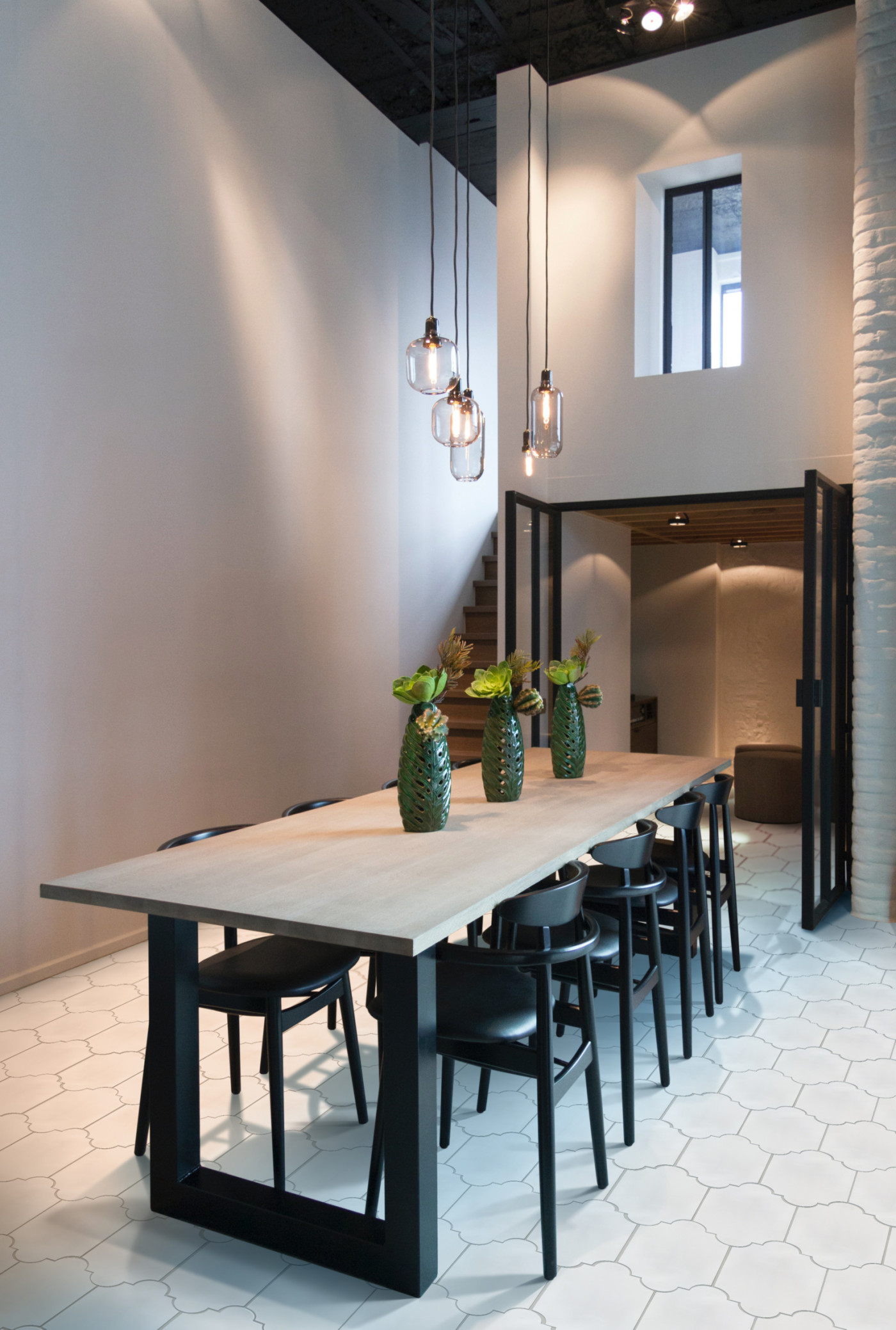 a dining room with a white table and chairs and a white tiled floor.