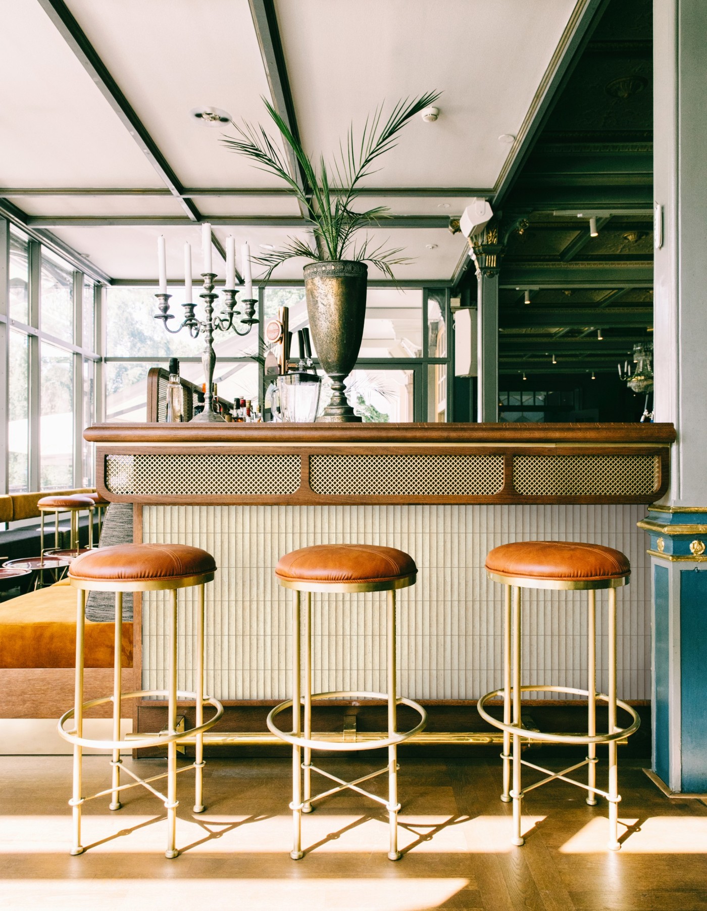 three stools in a bar with vertical tile above the kickplate.