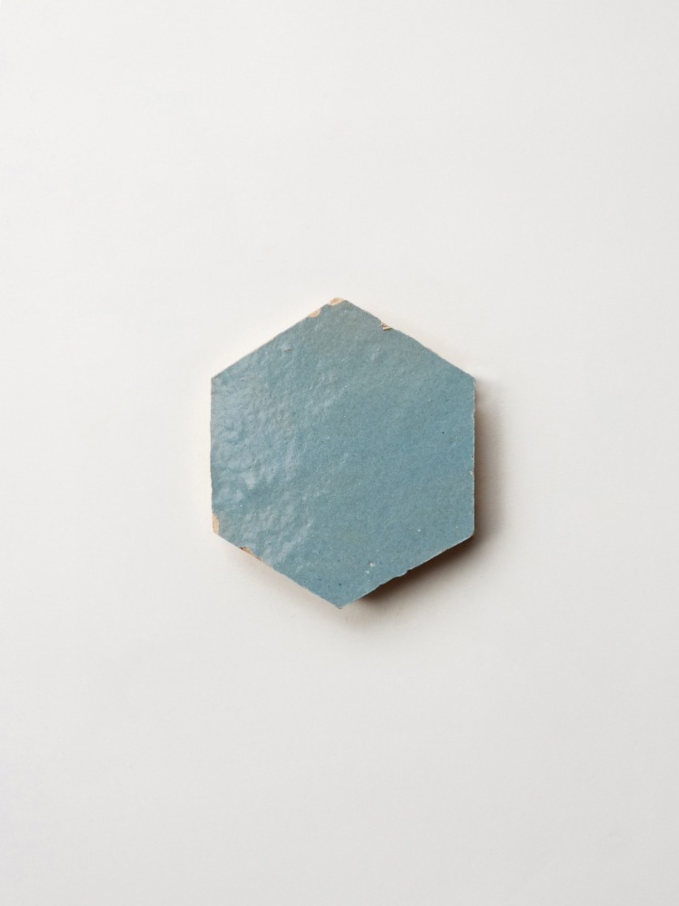 a blue hexagonal tile on a white surface.