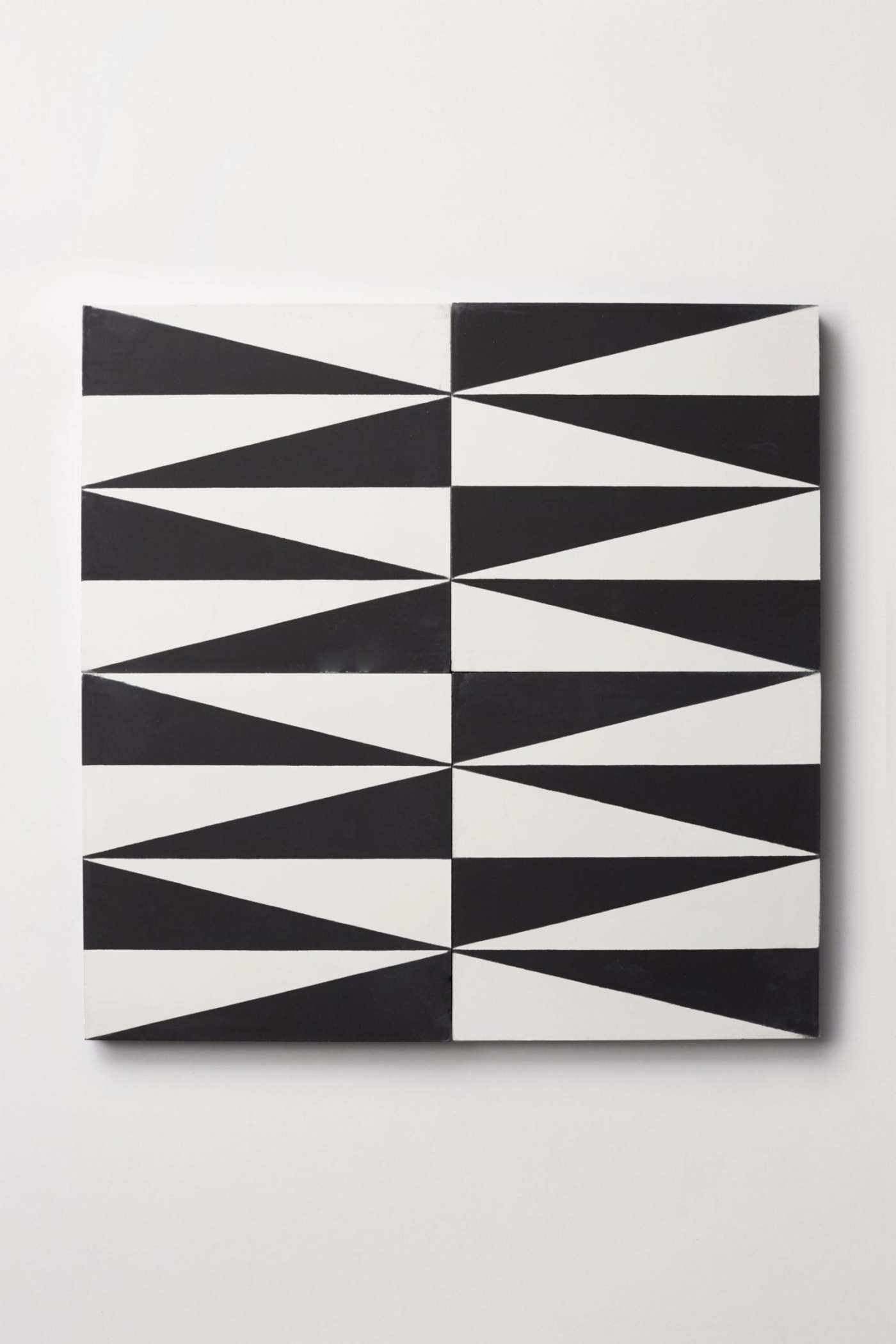 four black and white tiles with triangular designs on them.