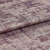 A folded roll of textured metallic mauve upholstery fabric with irregular crushed pattern â€” lying flat, photographed close-up under soft studio lighting to highlight its sheen.