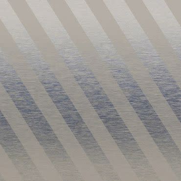 Diagonal-striped fabric window blind across the frame, alternating opaque beige and semi-translucent gray bands; filtering daylight and casting muted banded shadows; softly lit interior with a subtle textured surface visible behind.