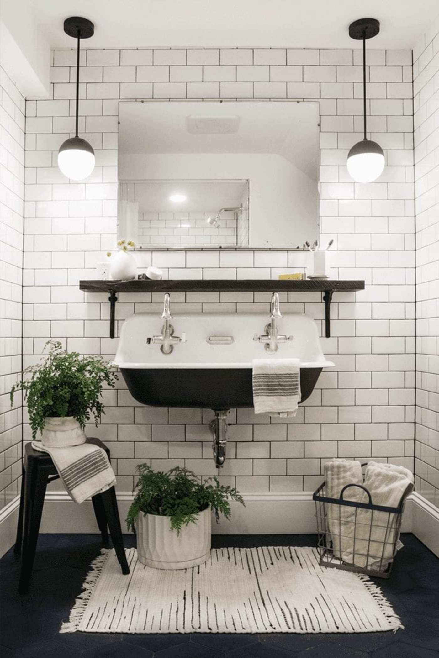 a bathroom with black and white tile and a sink.