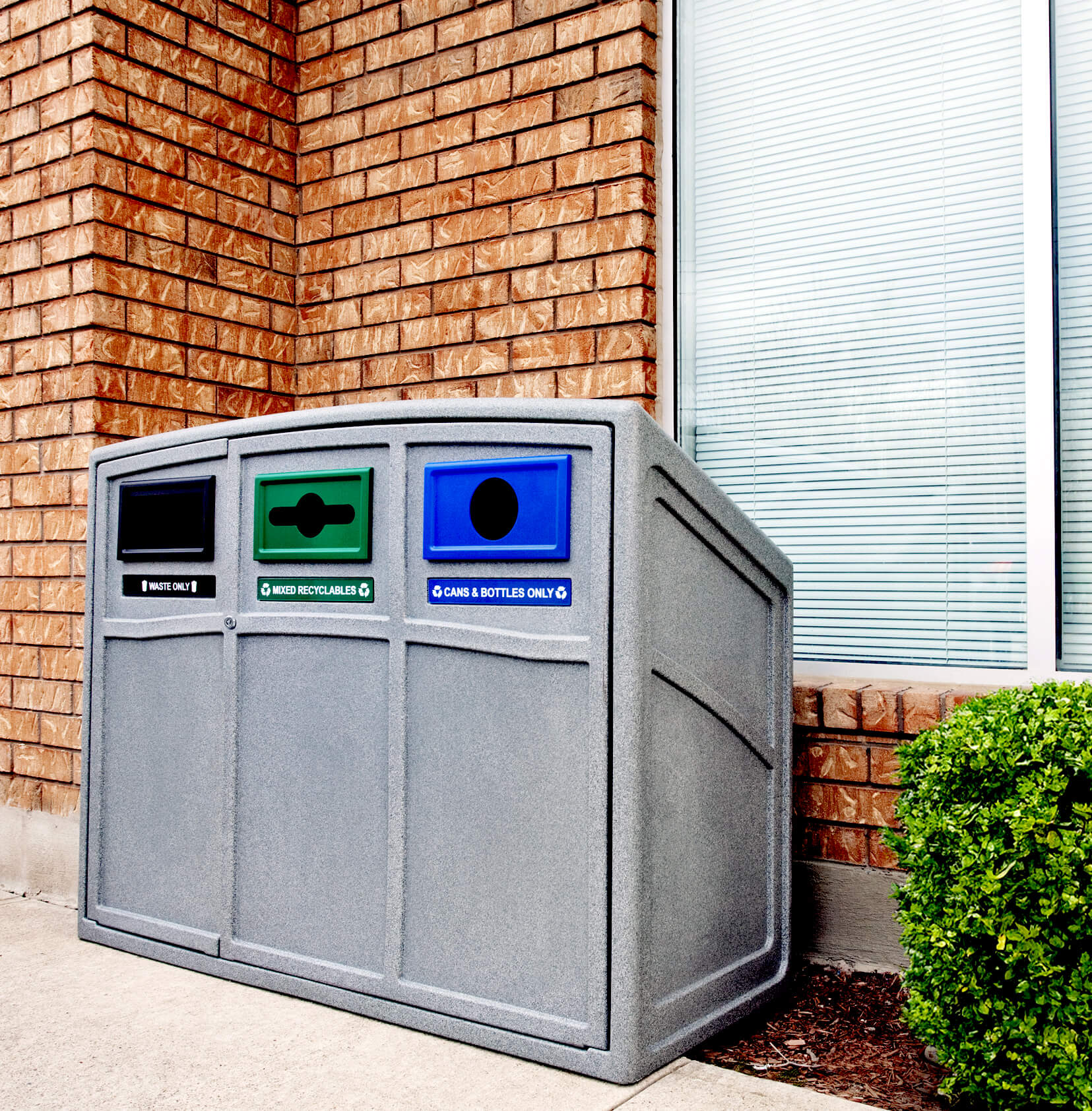 triple waste and recycling container for collecting garbage organics and cans and bottles placed outside a corporate office building