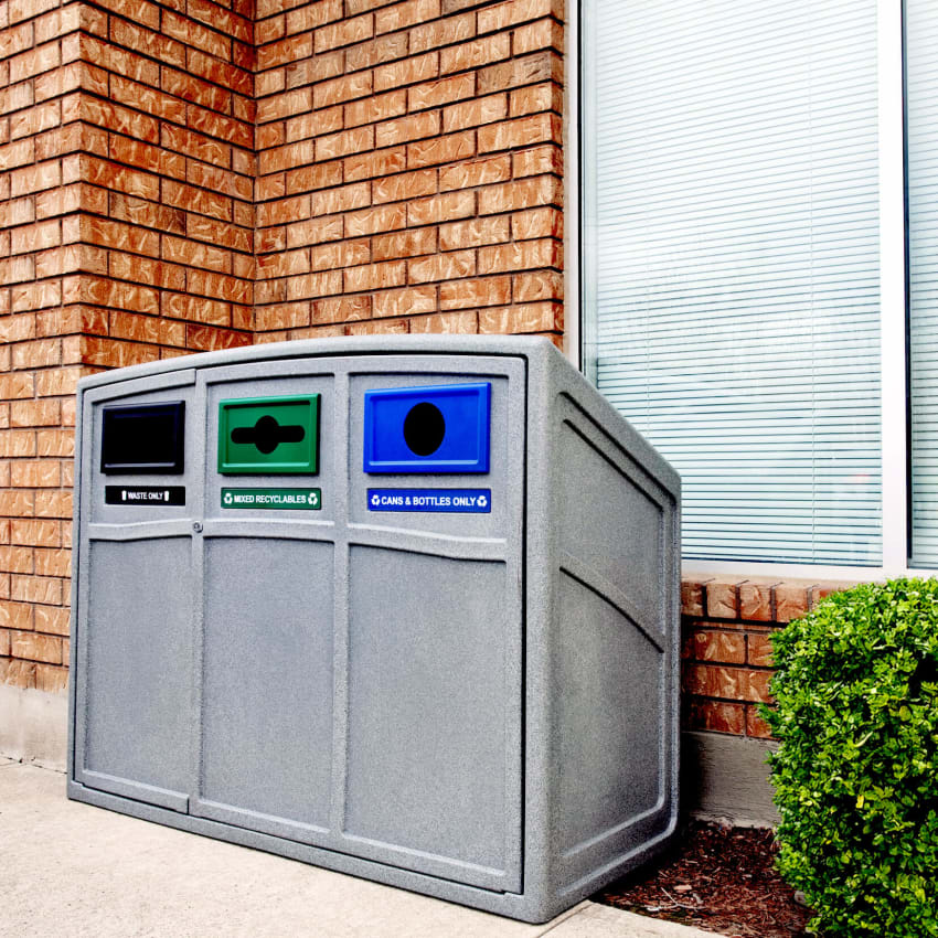 triple waste and recycling container for collecting garbage organics and cans and bottles placed outside a corporate office building