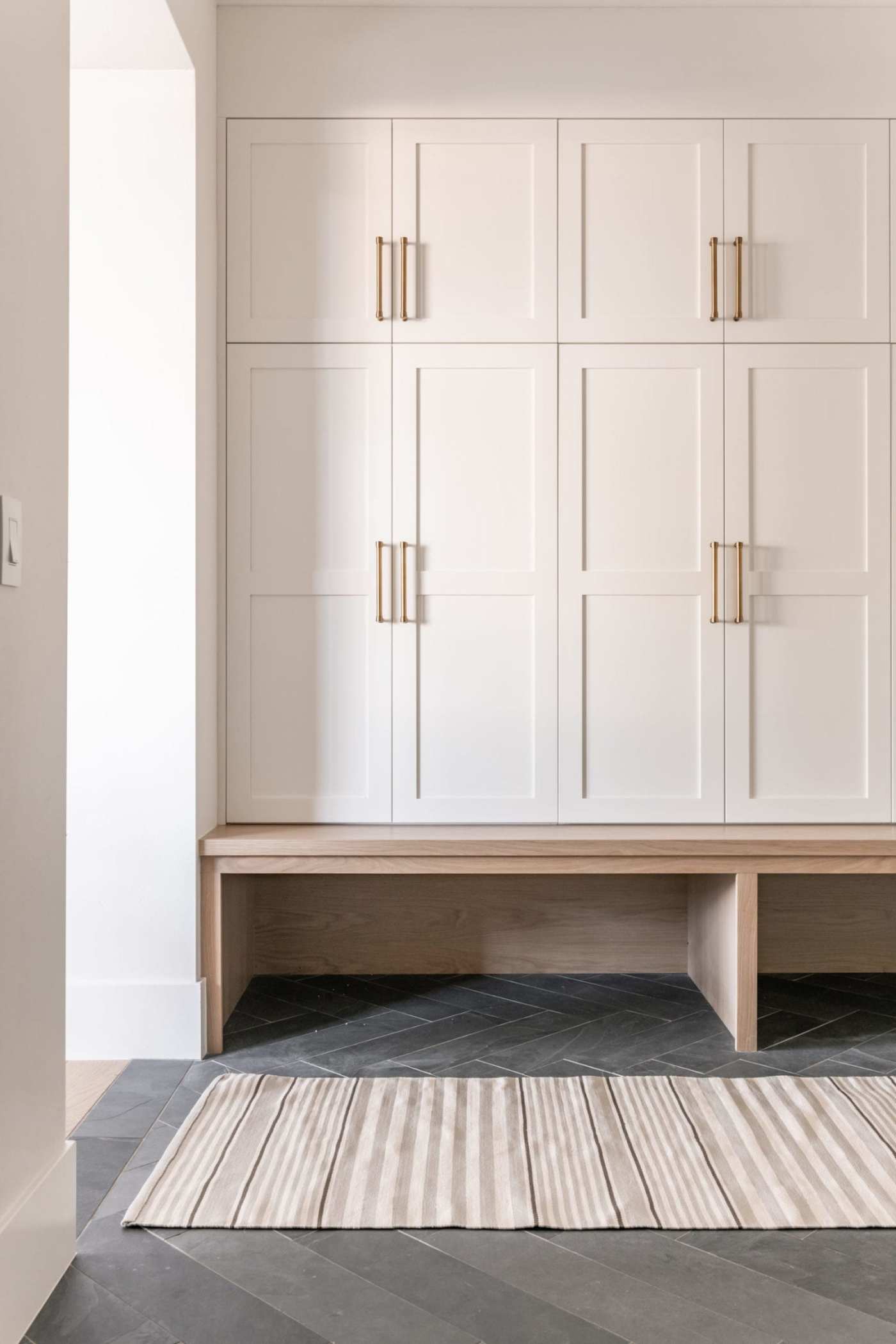 a room with white wooden cabinets and a rug.