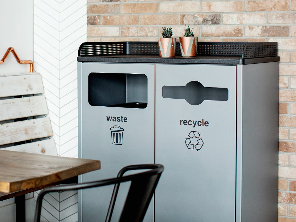 durable powder coated steel waste and recycling bin with built-in tray holder in an upscale restaurant cafe