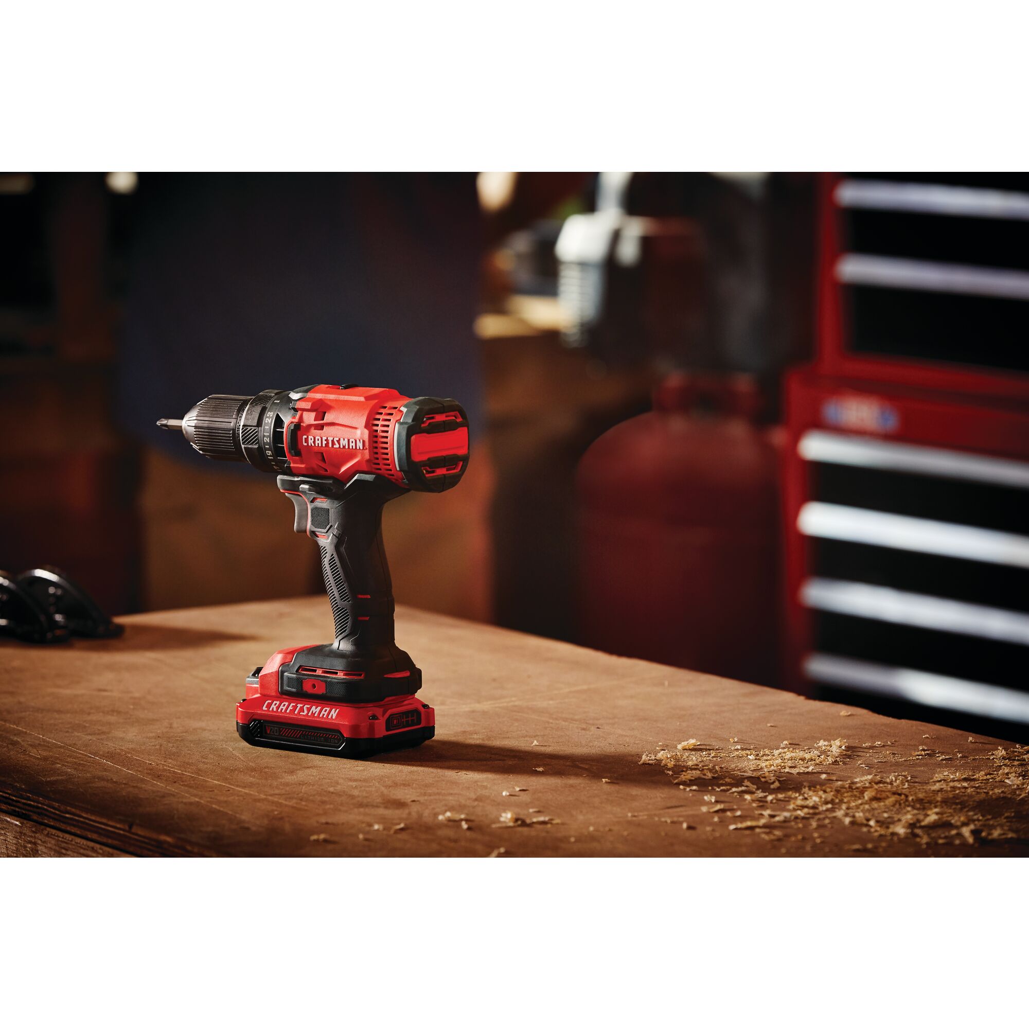 Cordless half inch drill and driver kit 1 battery placed on wooden table in workshop.