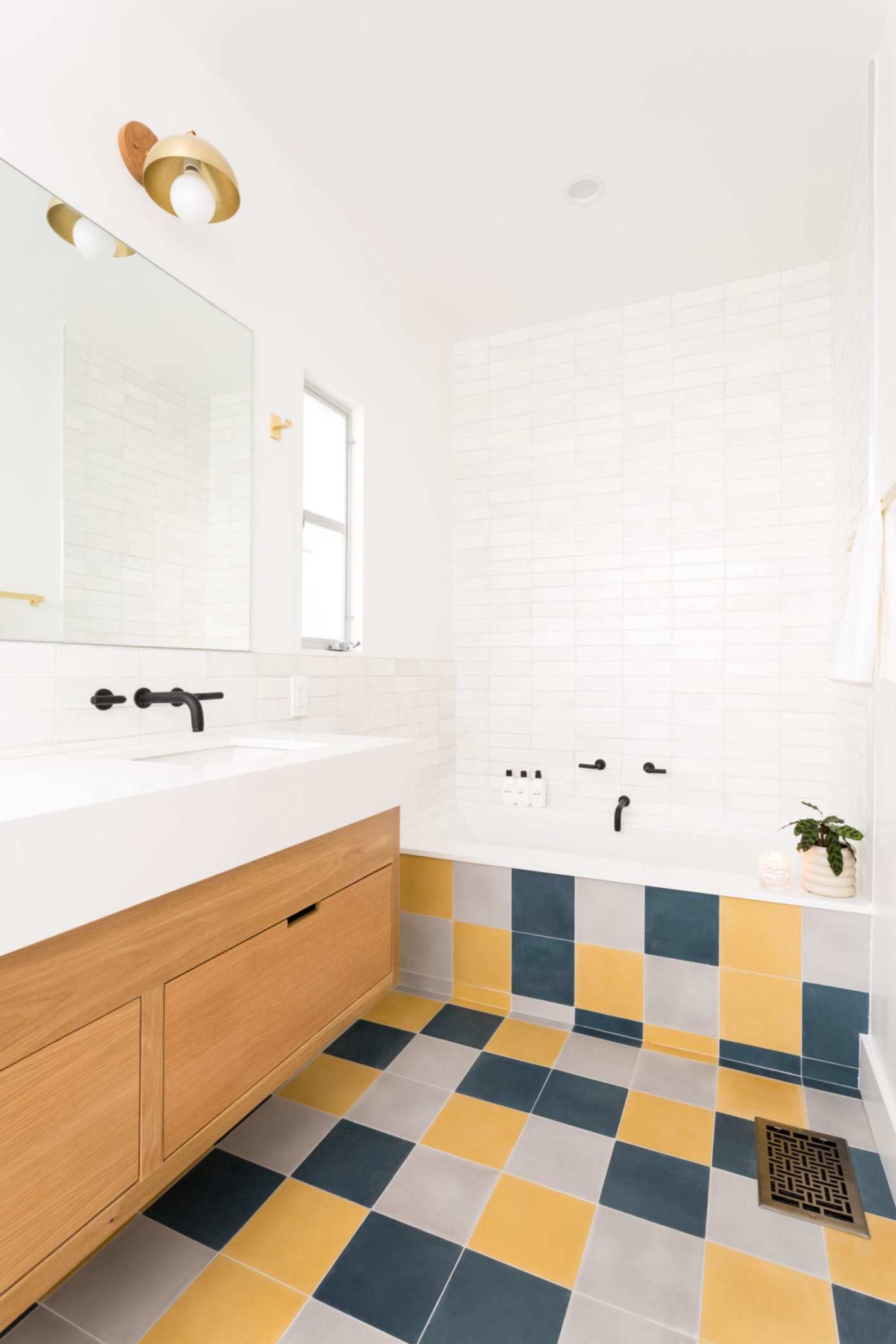 a bathroom with a yellow, grey, and blue tiled floor.