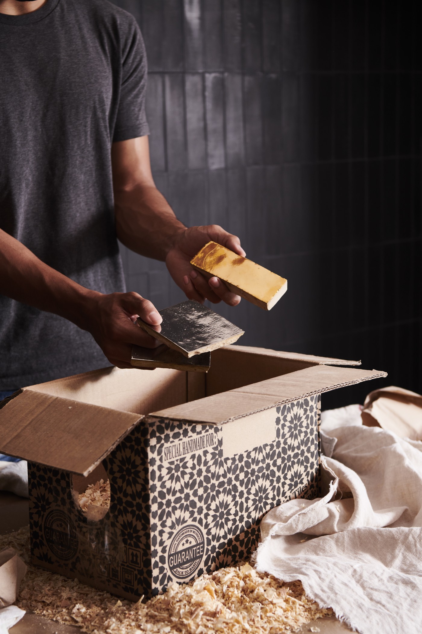 a man pulling tiles out of a box.