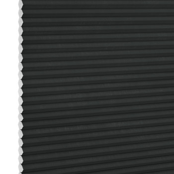 Black honeycomb (cellular) blind, fully lowered and closed with visible white hexagonal cell ends at left, blocking light; close-up interior view with neutral lighting.