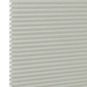 Cream cellular (honeycomb) window blind, fully lowered with visible hexagonal pleats at the left edge; closed and diffusing light; close-up against a plain white background with soft lighting.