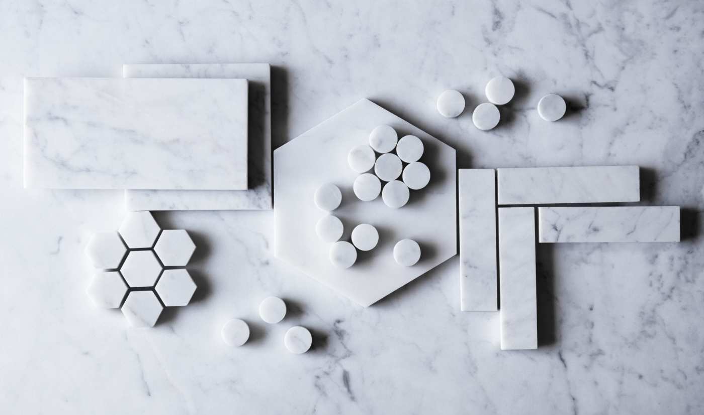 various shapes of white marble tile on a white surface.