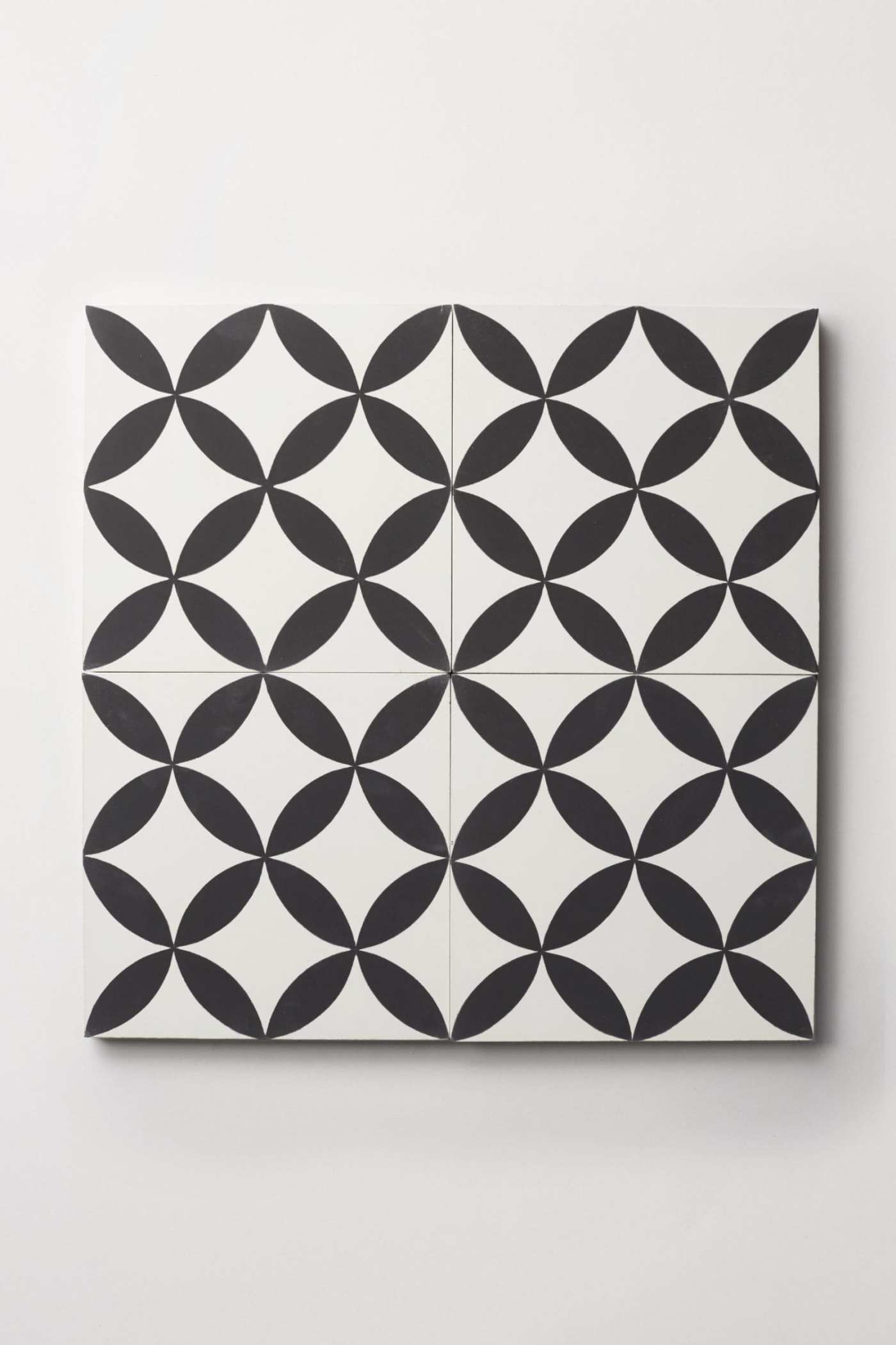 four black and white tiles on a white surface.