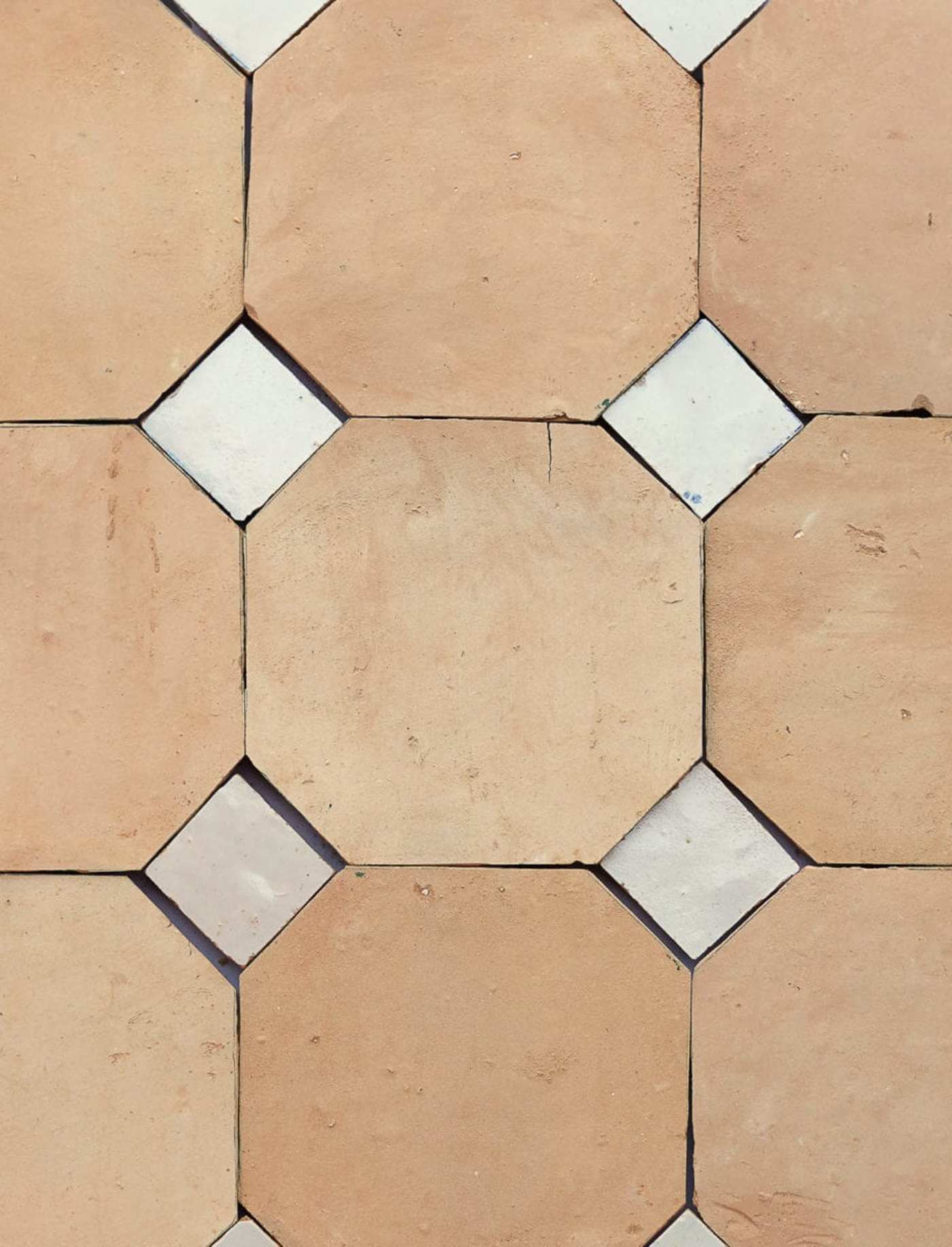 a close up of a tile floor with white and beige squares.