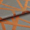 Woven gray-blue fabric with wide rust-orange geometric stripes, folded and overlapped; textured, slightly metallic sheen visible under soft studio lighting in a close-up view.