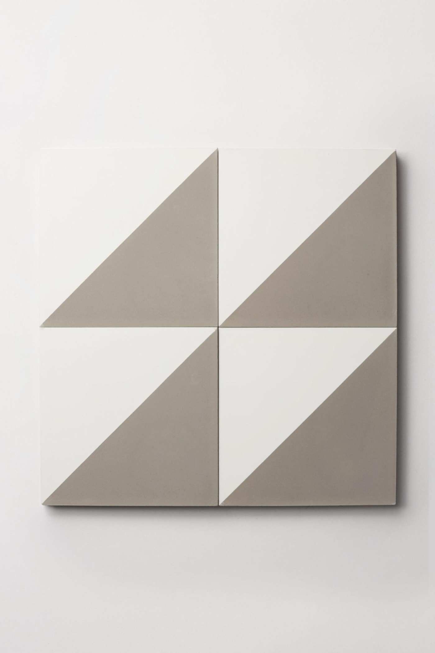 four white and grey tiles on a white surface.