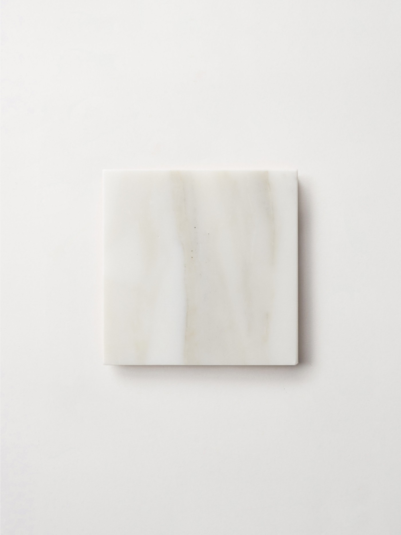 a white marble square on a white surface.