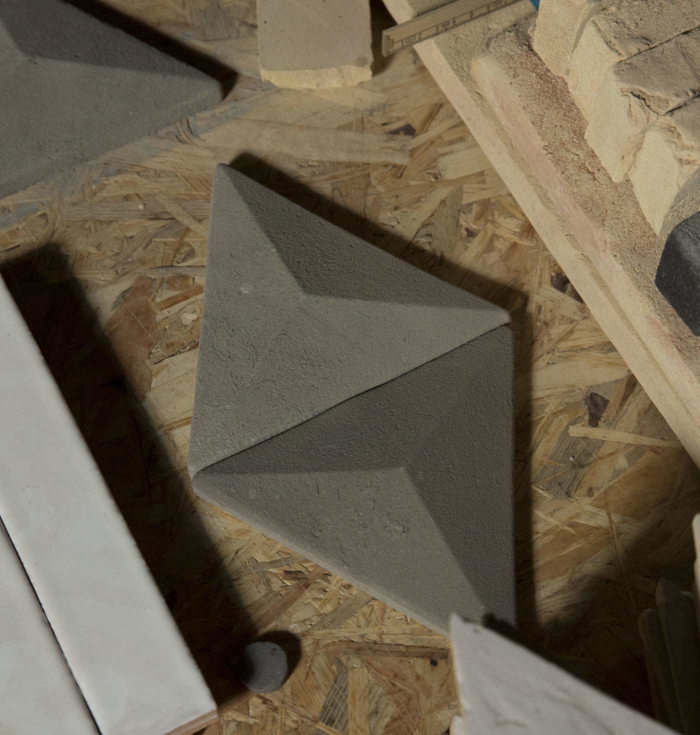 a pile of bricks and tiles on a wooden floor.