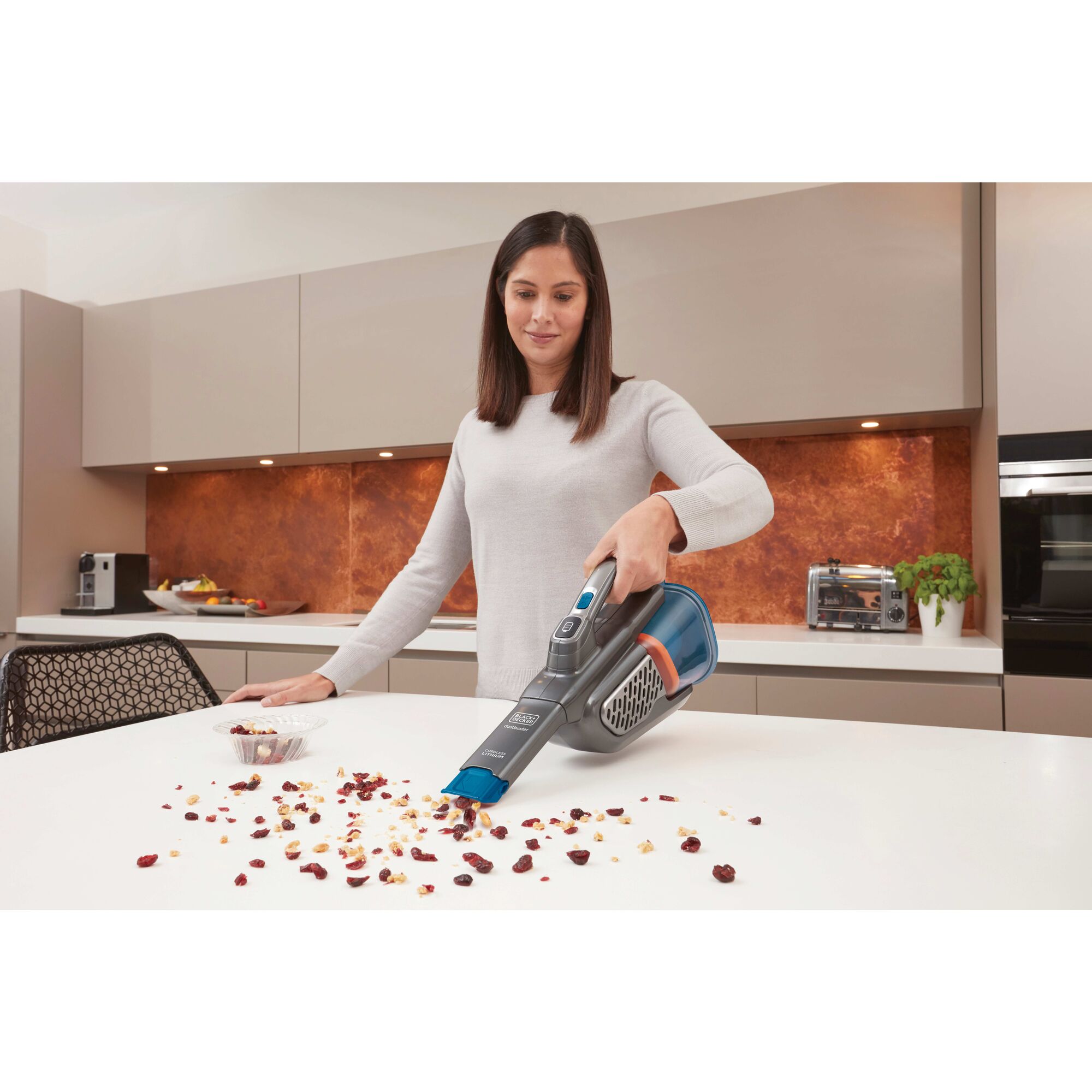 Woman cleaning kitchen counter with BLACK+DECKER dustbuster