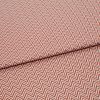 Chevron-patterned textile (red and white) folded across the frame, showing tight zigzag lines; fabric lies flat with a single fold, photographed in even studio lighting on a neutral background.