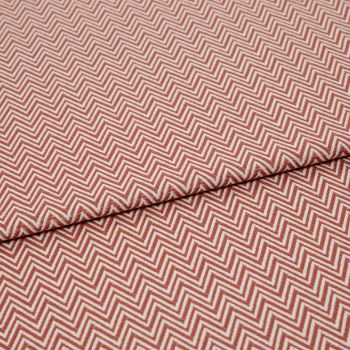 Chevron-patterned textile (red and white) folded across the frame, showing tight zigzag lines; fabric lies flat with a single fold, photographed in even studio lighting on a neutral background.