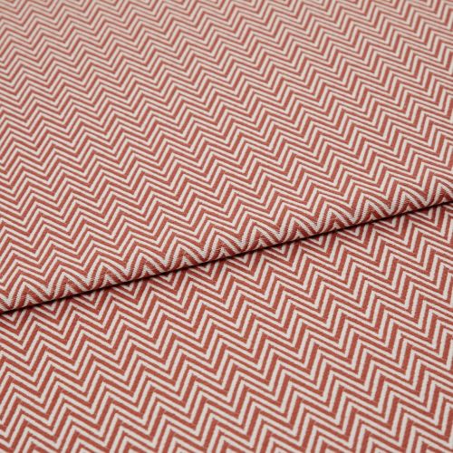 Chevron-patterned textile (red and white) folded across the frame, showing tight zigzag lines; fabric lies flat with a single fold, photographed in even studio lighting on a neutral background.