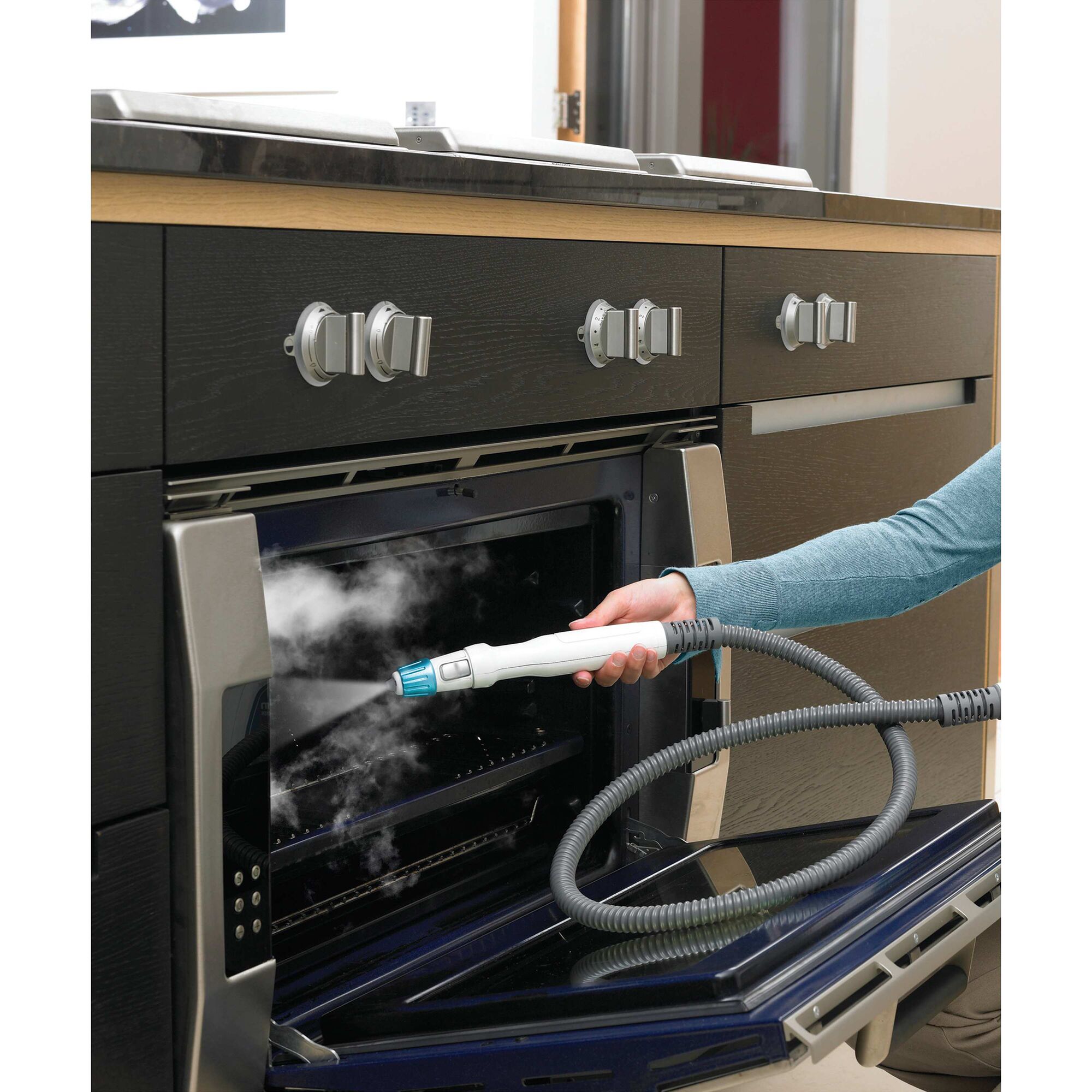 8 in 1 complete steam cleaning system being used to clean kitchen oven.