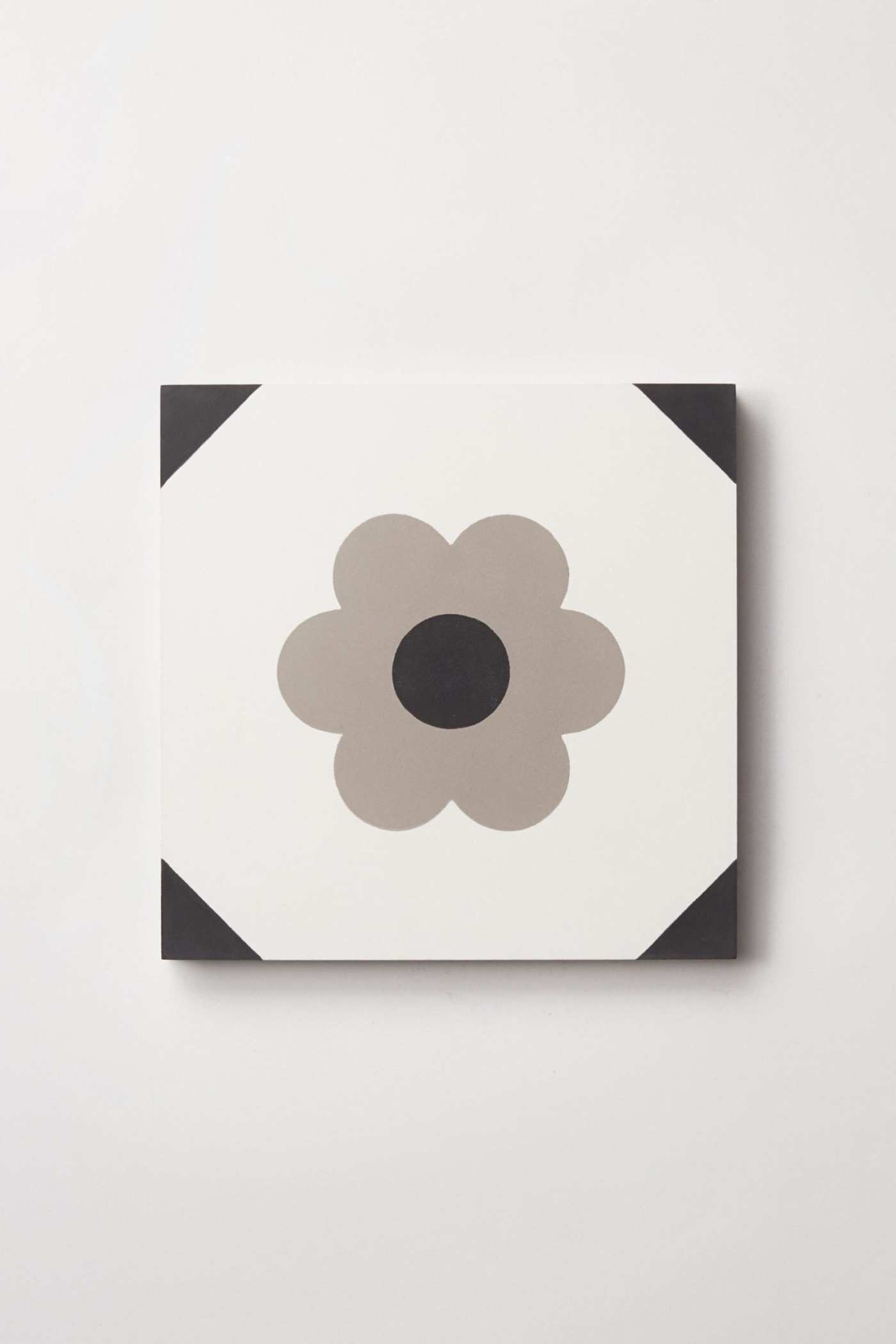 a black and white tile with a flower on it.