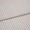 Beige woven fabric with thin vertical gray pinstripes, folded once and overlapping, lying flat as a sample in soft, diffuse lightingâ€”close-up view emphasizing texture and pattern.