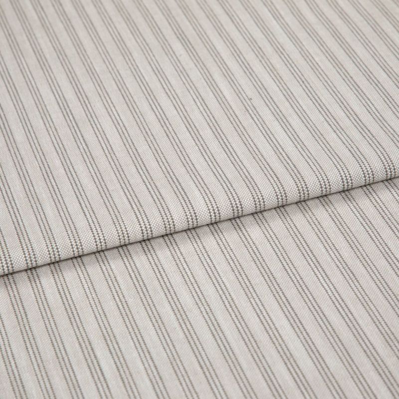 Beige woven fabric with thin vertical gray pinstripes, folded once and overlapping, lying flat as a sample in soft, diffuse lightingâ€”close-up view emphasizing texture and pattern.