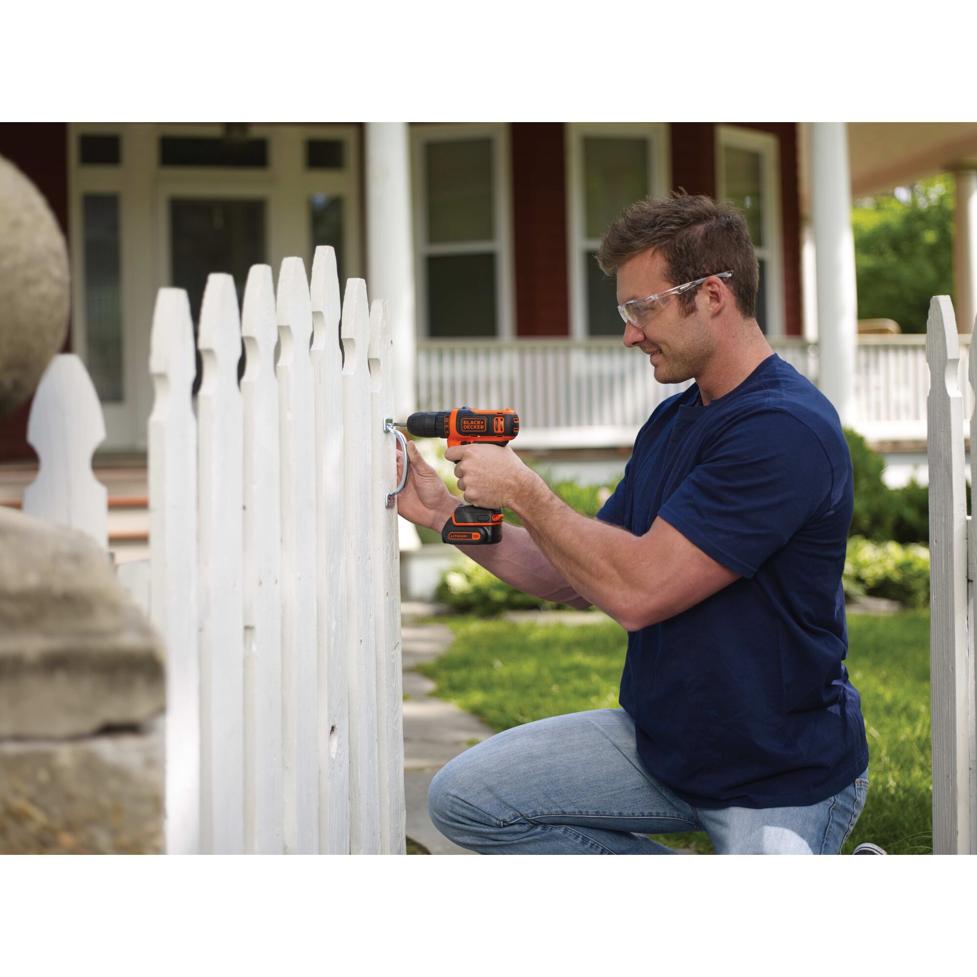 Person using 12 volt max cordless drill driver to assemble a white picket fence