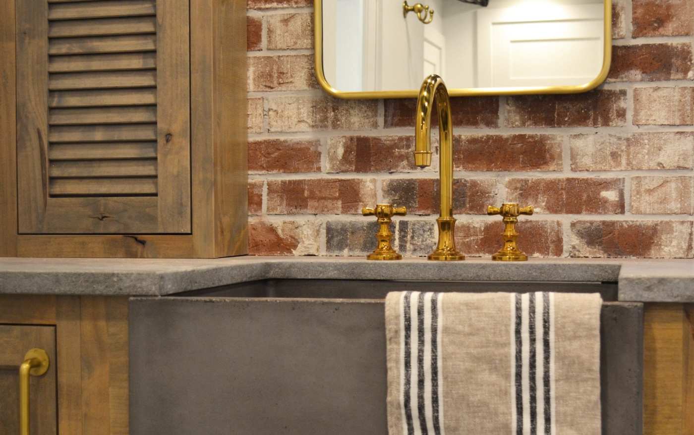 a bathroom with a sink, a brick backsplash, and a mirror.