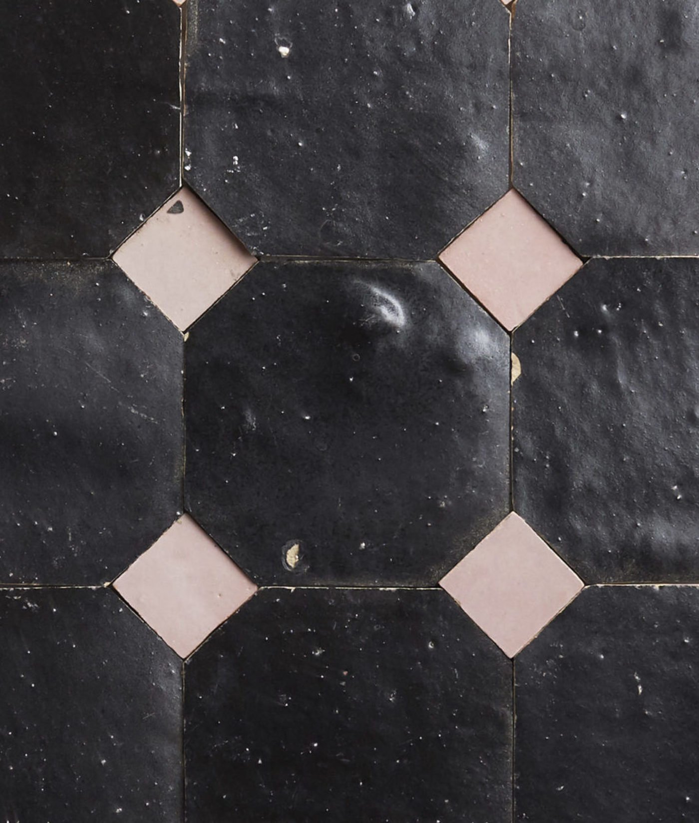 a close up of a black and pink tile.