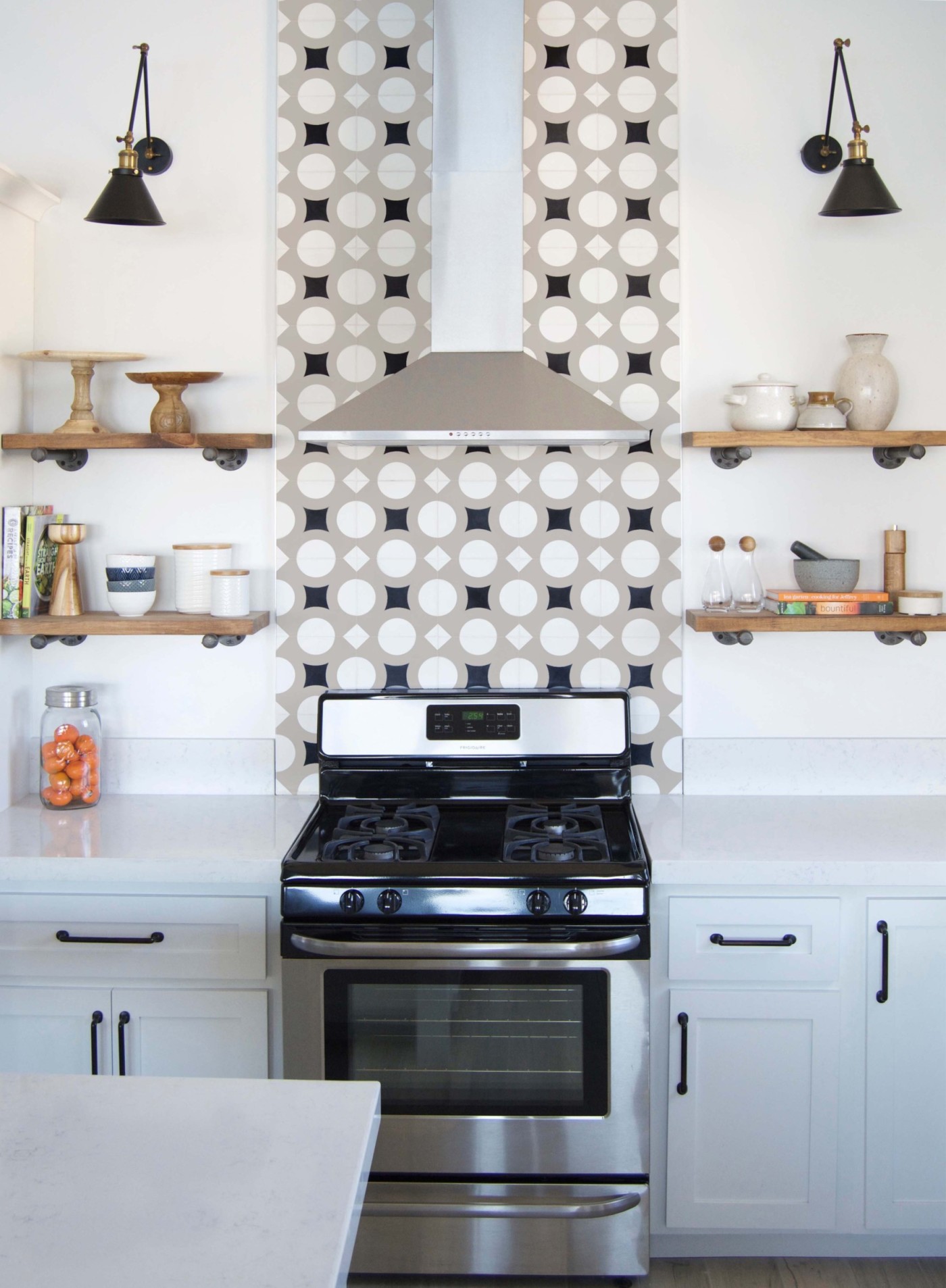 a black and white kitchen with a stove and shelves.