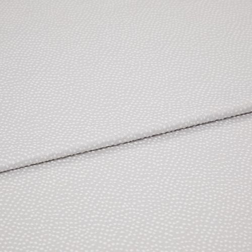 Light-gray fabric with small white dotted texture, folded diagonally with an overlapping edge; close-up view on a plain surface under soft, even lighting.