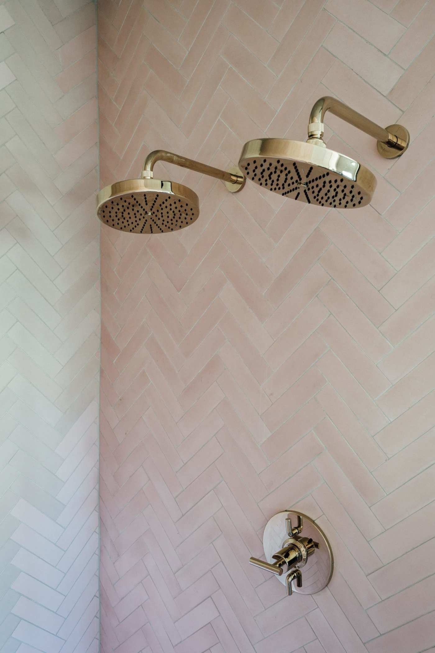 a shower with a pink tiled wall.