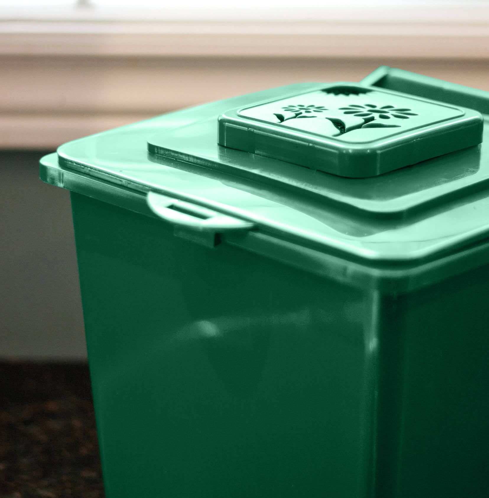 closeup images showing the vented lid on a green plastic organics collection bin
