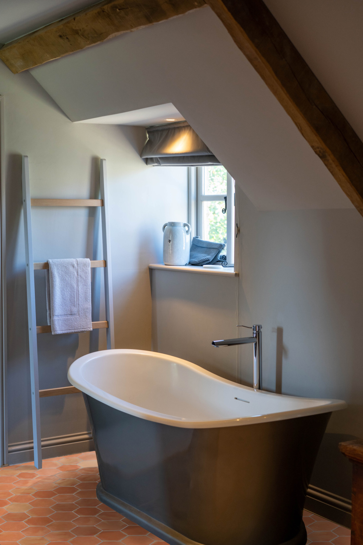 a bathtub in a bathroom with a red tiled floor.