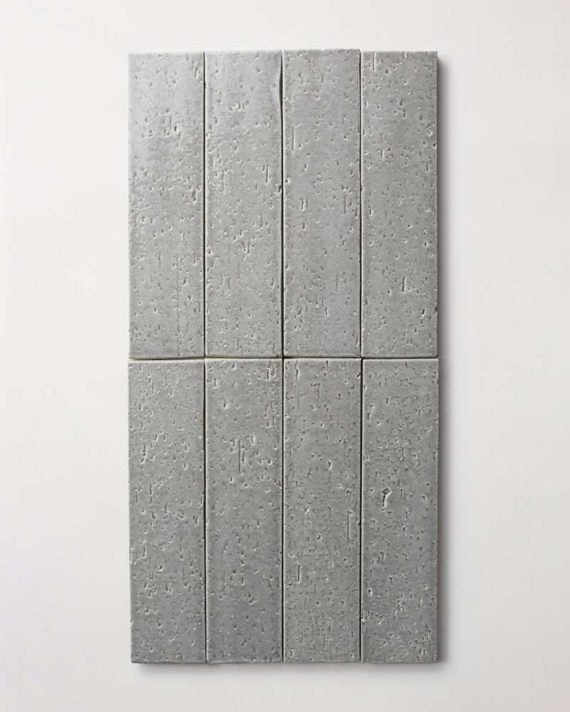 a gray tiled wall hanging on a white wall.