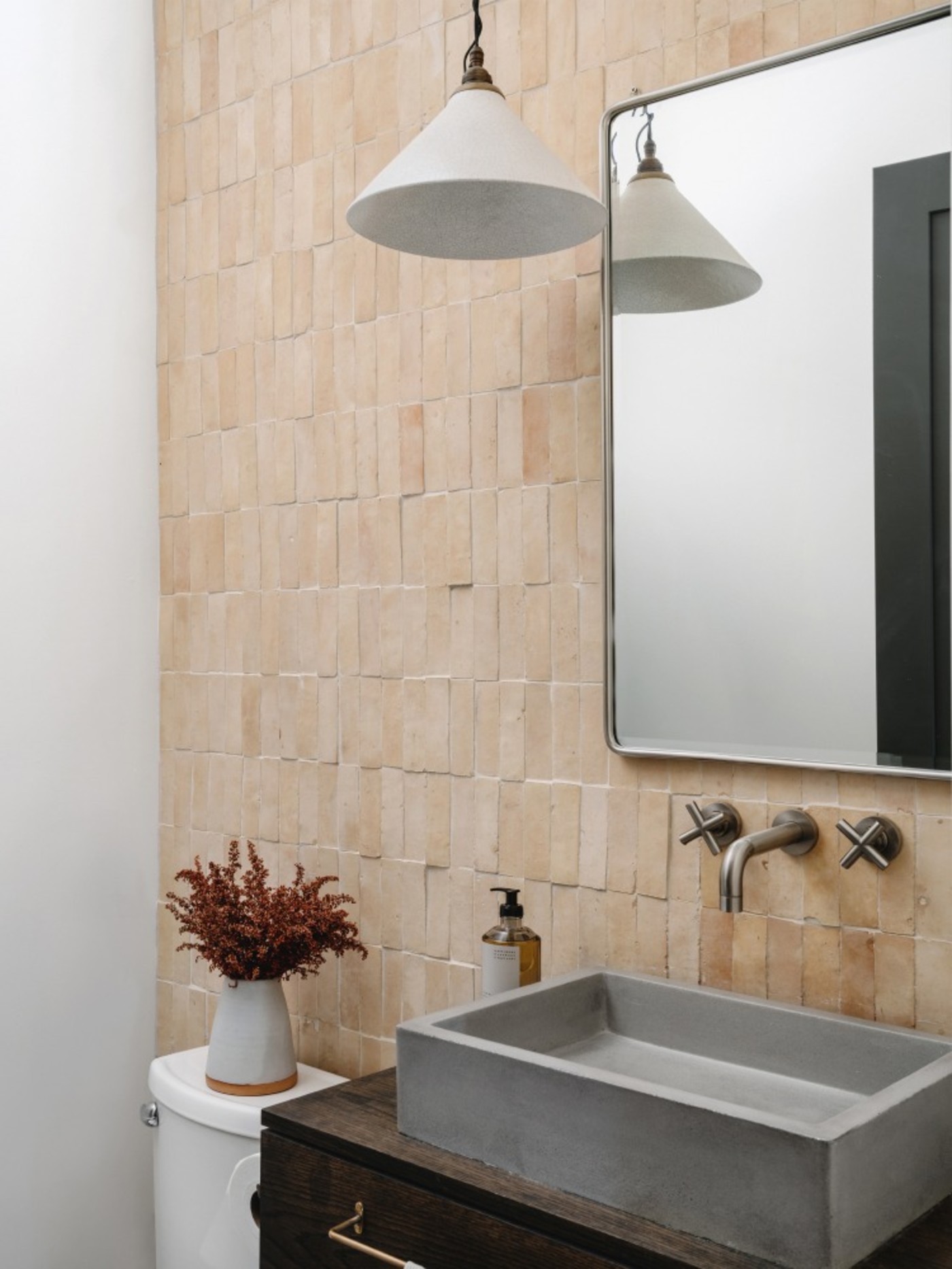 a bathroom with a sink, beige tile backsplash and mirror.